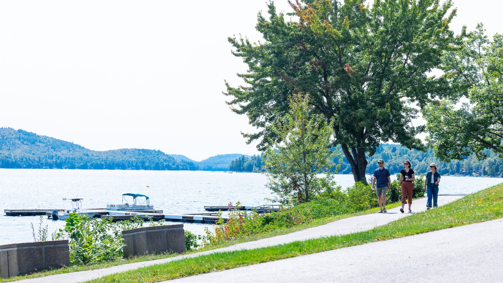 three people walking towards the beach on Schroon Lake